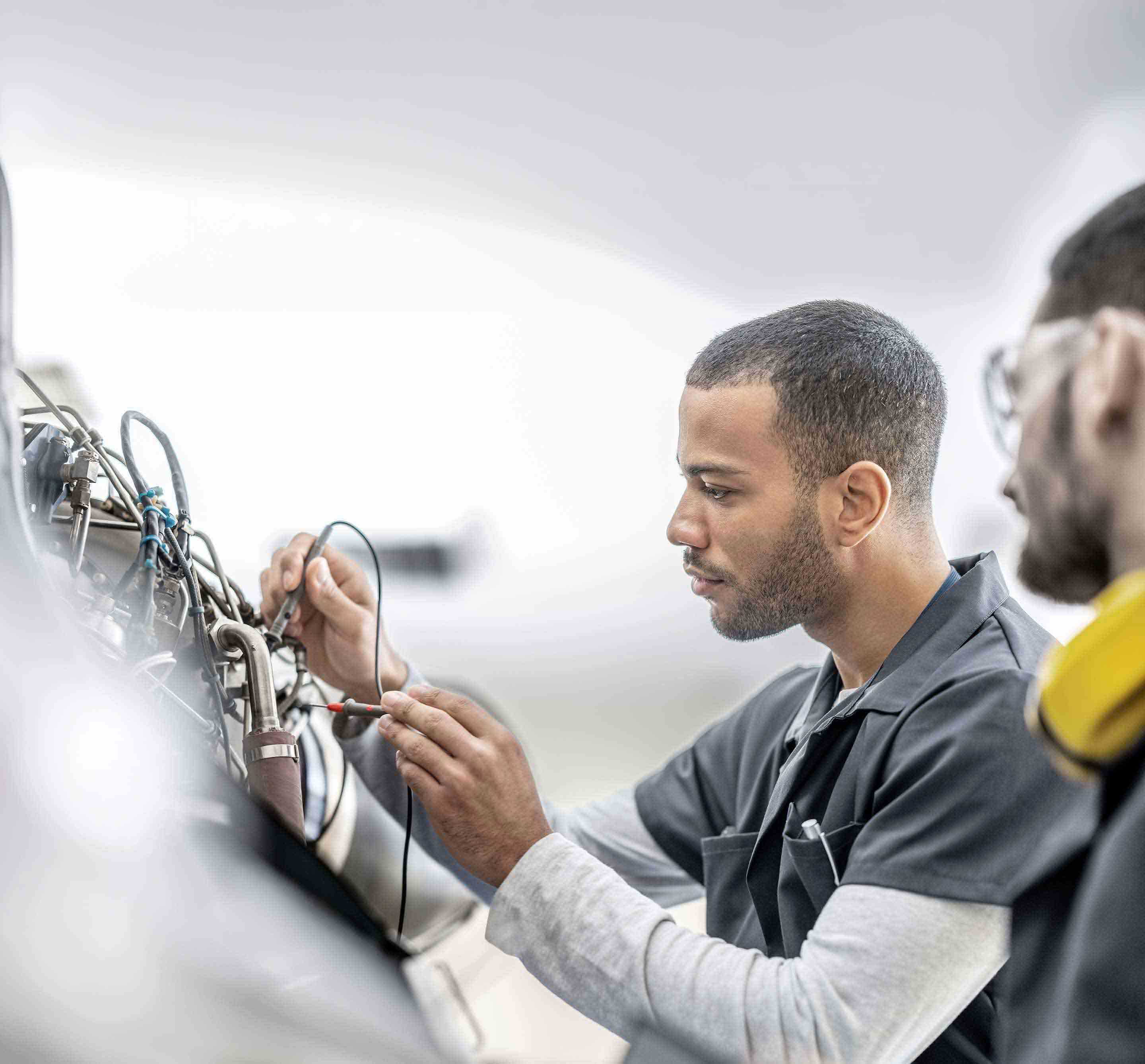 Maintenance professional testing avionics connections inside an aircraft service environment.