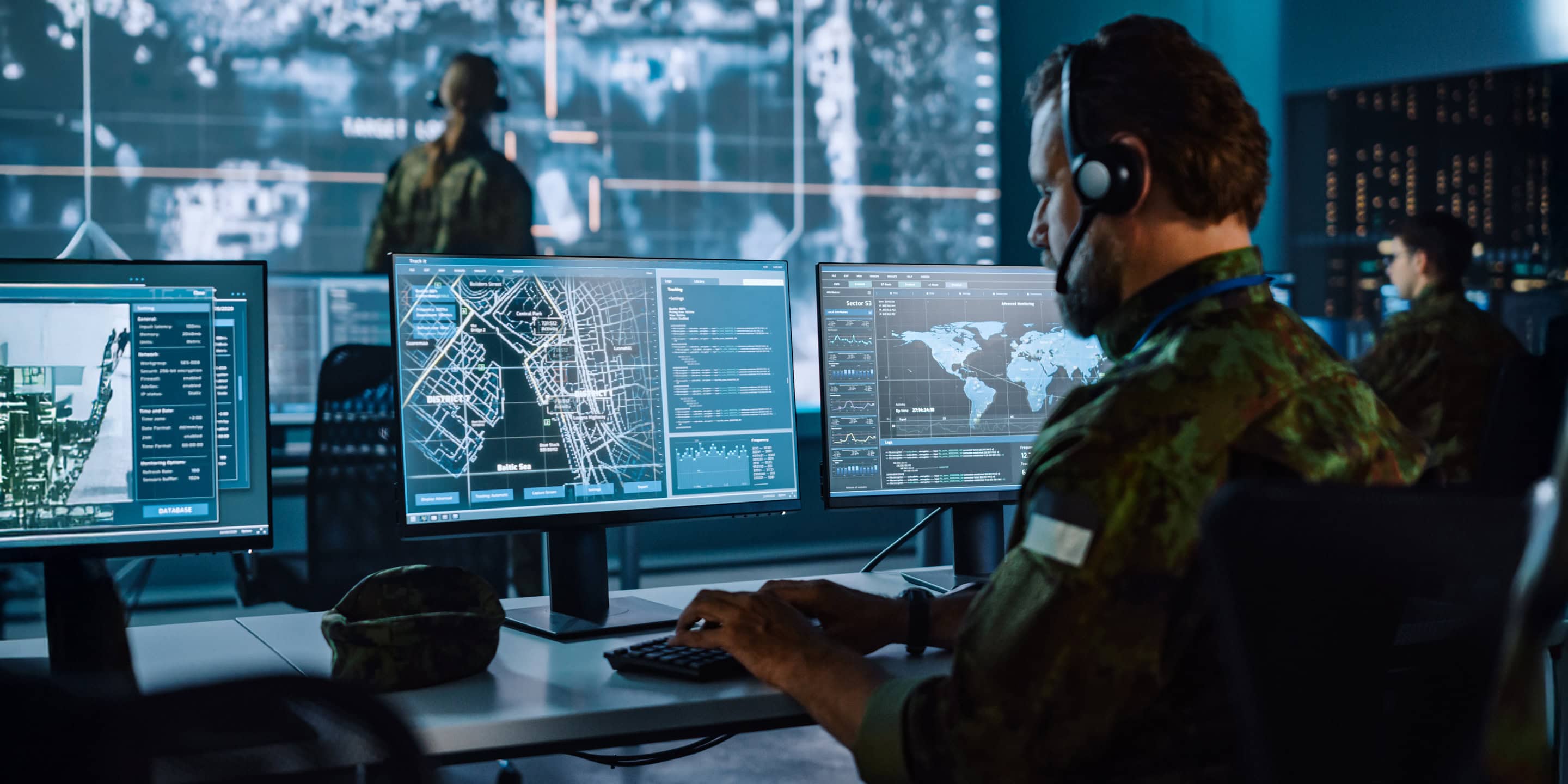 Cyber defense specialist observing network activity on multiple displays